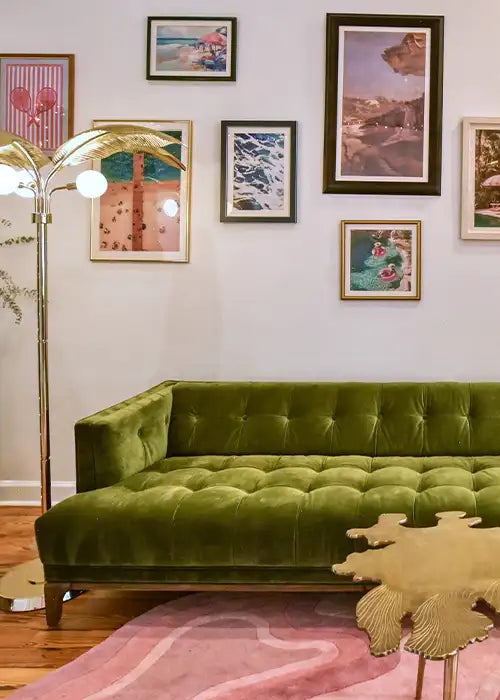 A vibrant living room featuring a green tufted sofa, a curated gallery wall of colorful artwork, and a pink Jubi rug with flowing patterns, adding a modern yet inviting touch.