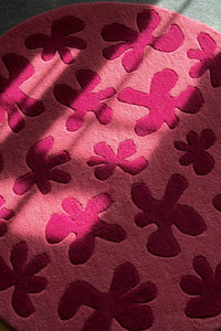 Close-up of pink flower textured round wool rug, colorful funky rug for cozy modern spaces lifestyle