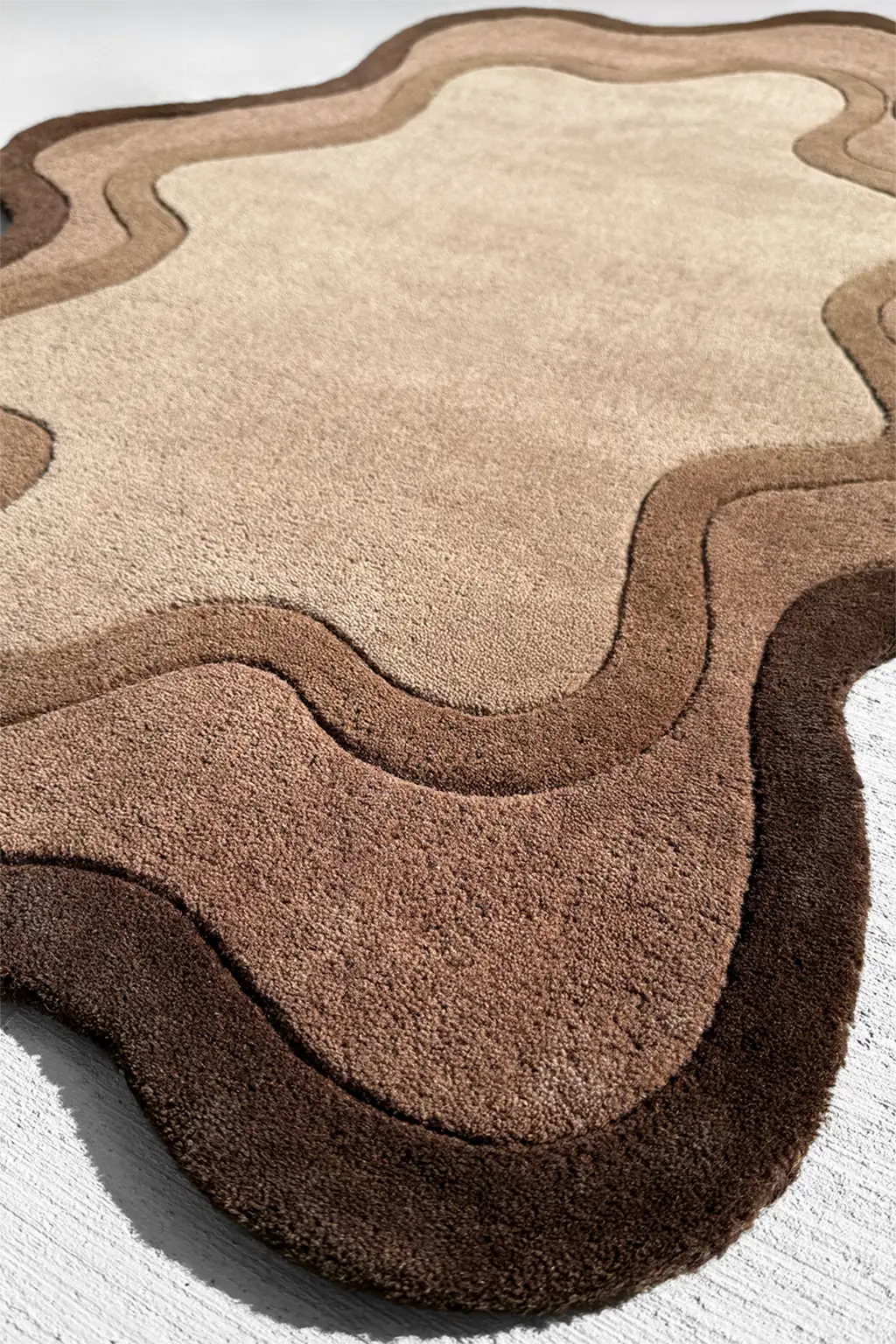Dark brown custom rug with wavy edges, an asymmetrical boutique rug for earthy and minimalist spaces

