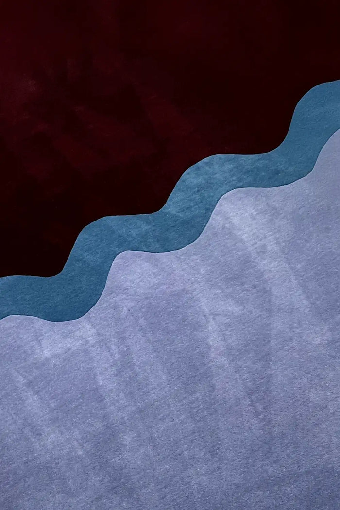Close-up of hand-carved wavy lines on purple and navy wool rug showing plush modern texture