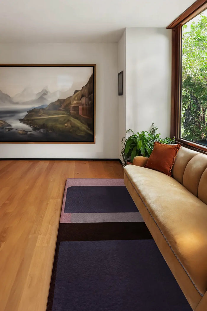 5x8 pink and purple modern wool rug styled in mid century living room with mustard velvet sofa lifestyle