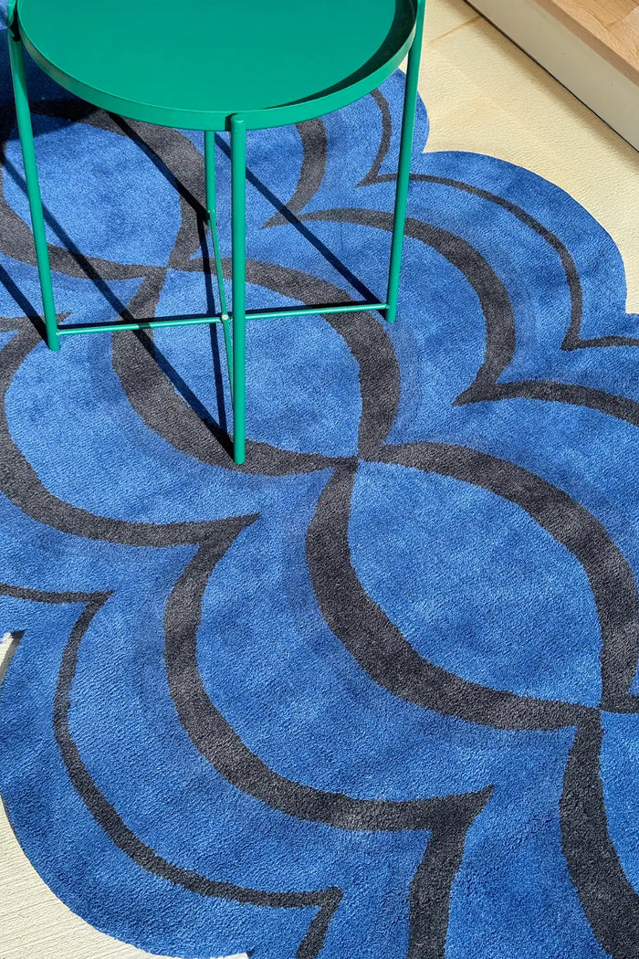 modern blue rug with a blue wavy design under an eclectic table
