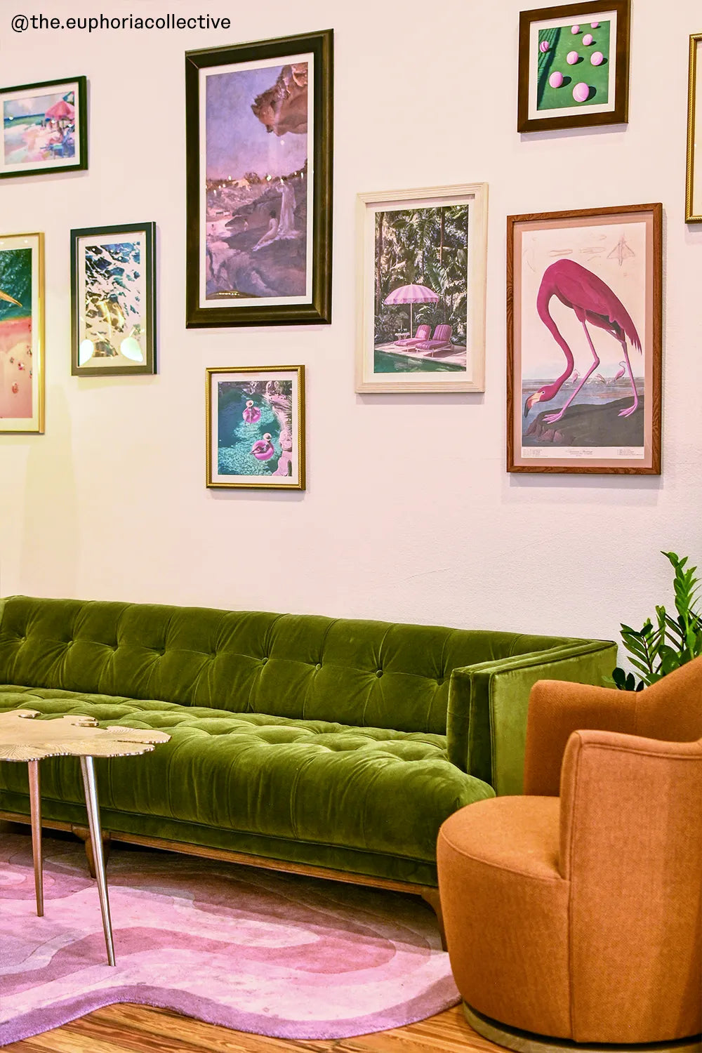 A stylish living room featuring a green velvet sofa, a gallery wall with vibrant art pieces, and a Jubi rug with soft pink tones, creating a cozy and artistic ambiance.