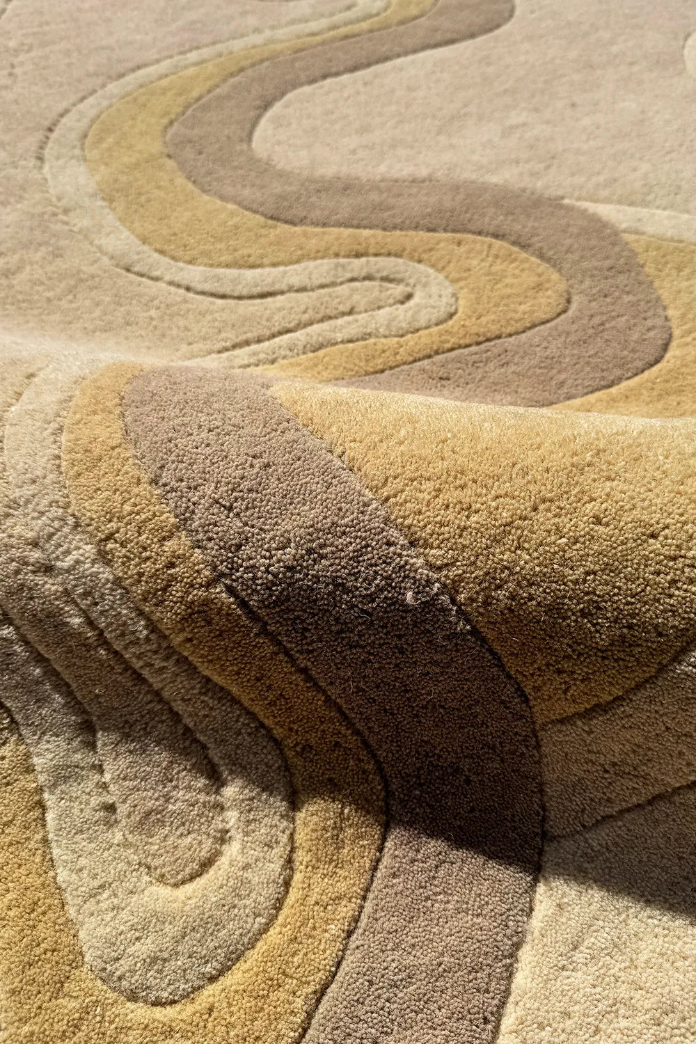 Sculpted-edge area rug with layered contours in warm, earthy neutrals
