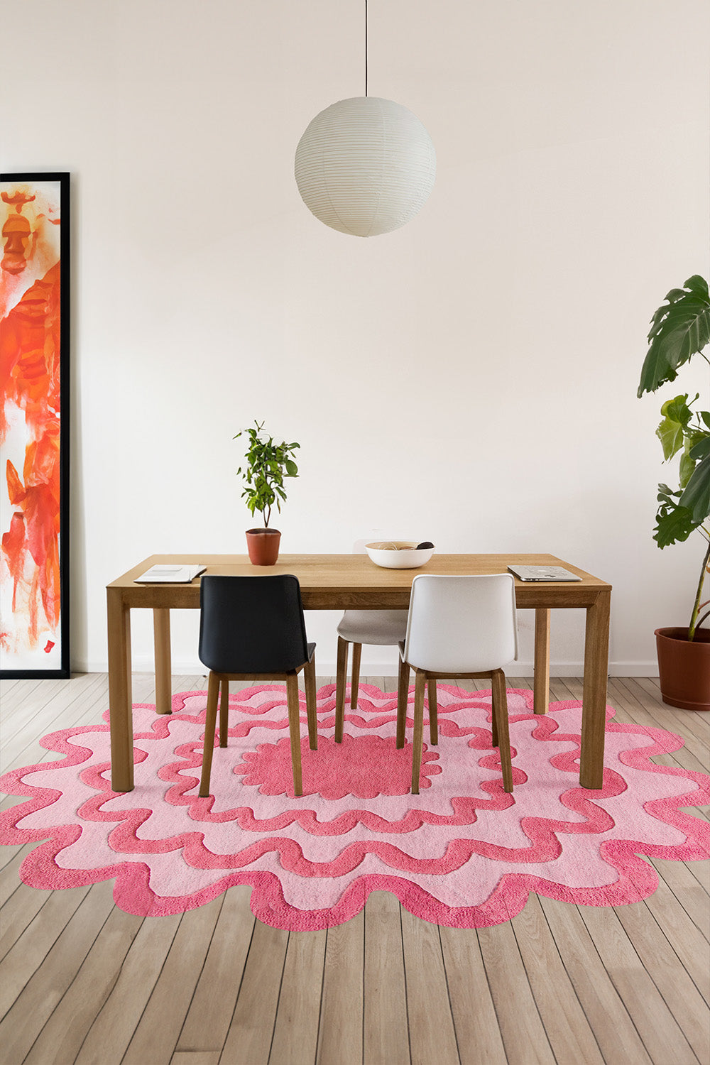 Pink ripple oval wool rug styled in a colorful modern dining room