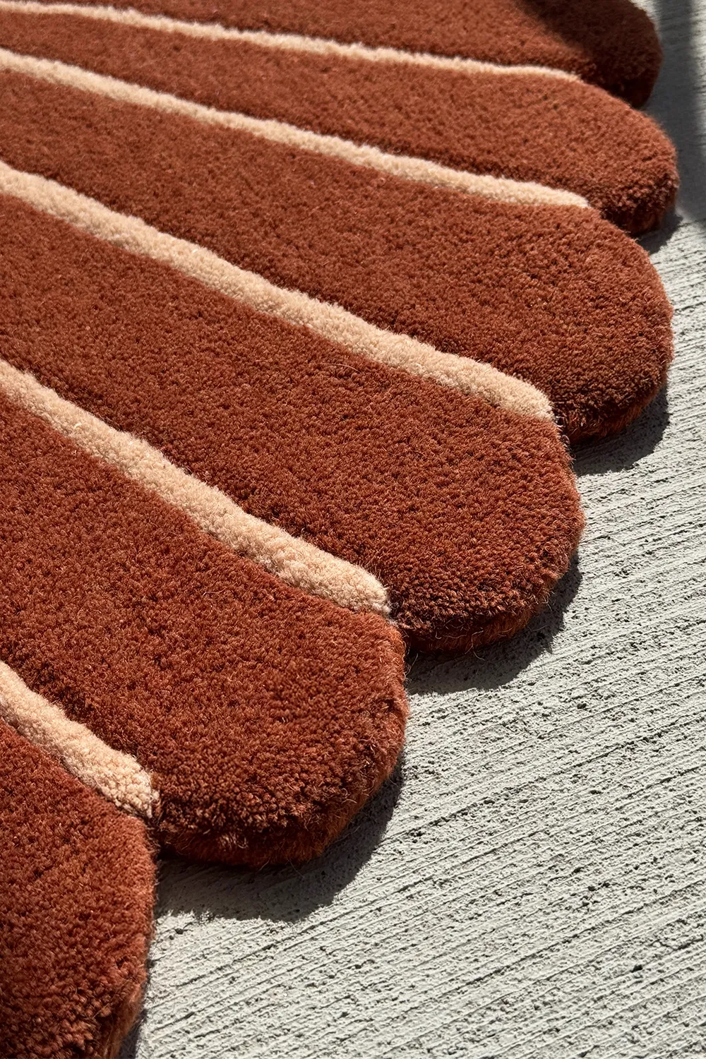 Sculptural brown and cream rug with thick wool pile and curved hand-tufted linework, inspired by nature