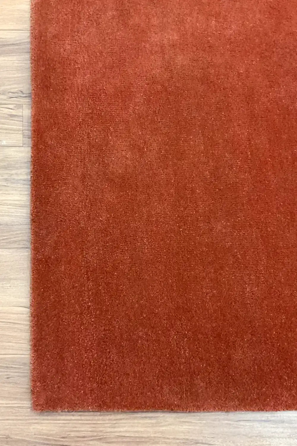 Solid terracotta wool rug, hand-tufted for a plush feel.
