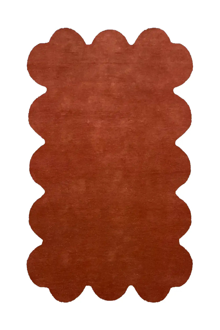 Rust-colored scalloped edge wool rug with a soft, modern design
