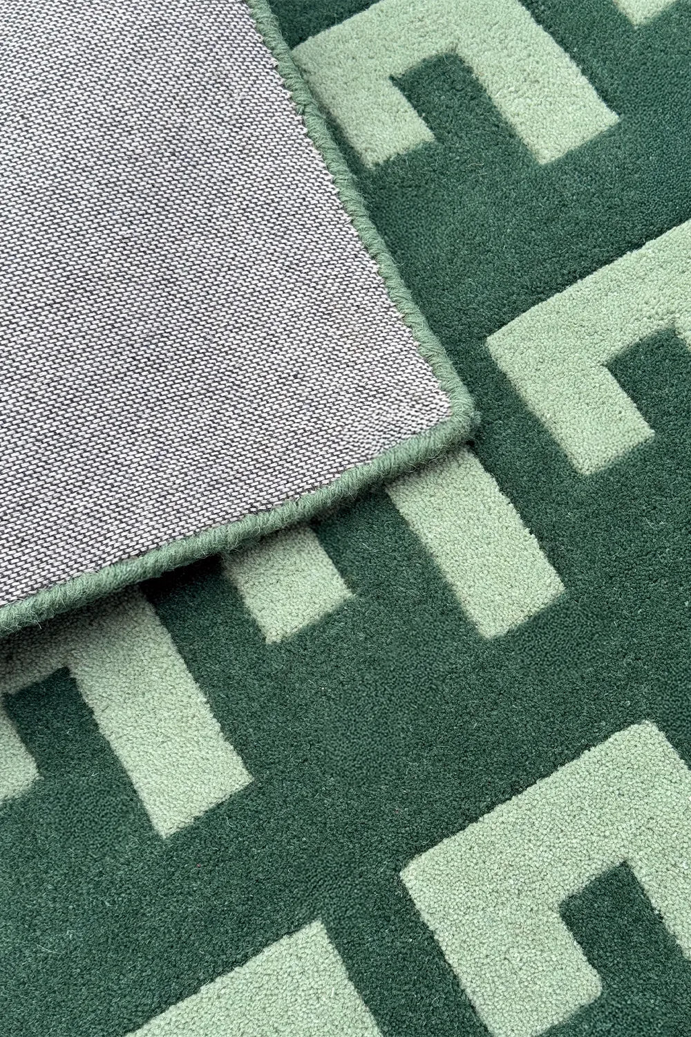 Sage and dark green graphic wool rug with bold mid-century pattern

