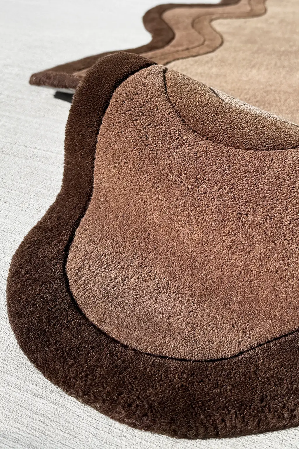 Plush texture of a modern brown wool rug with dark scalloped border for Japandi or boho interiors

