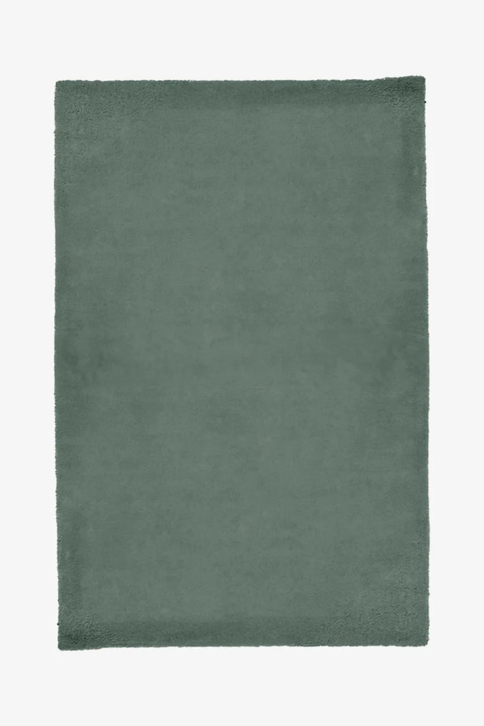 Solid olive green wool rug with dense texture, great for modern bedrooms or neutral-toned living spaces