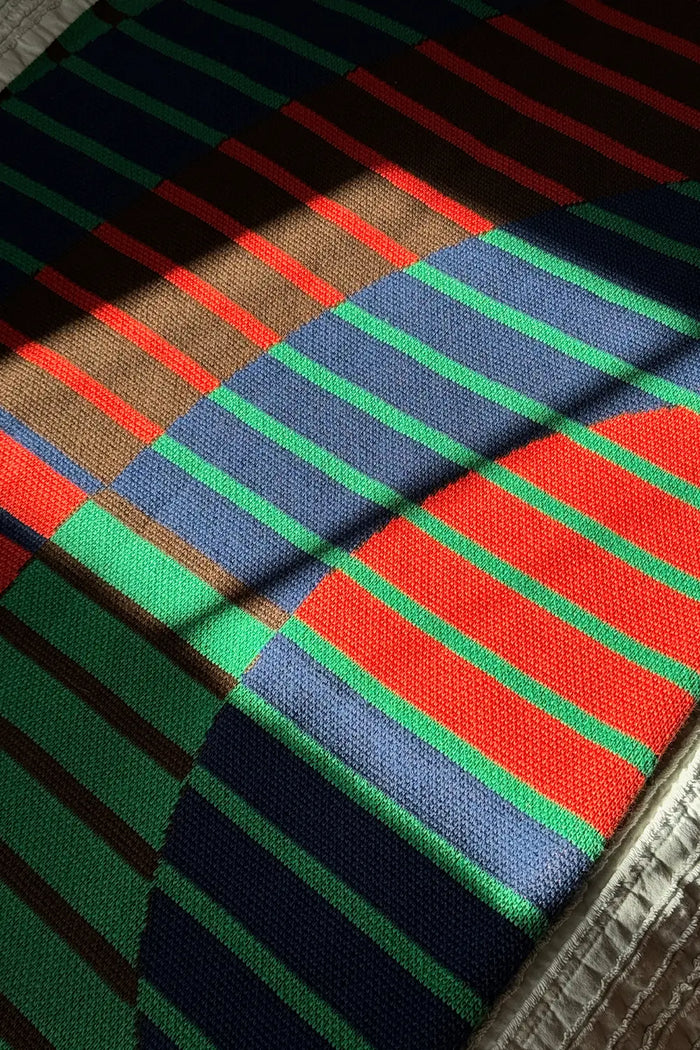 Combed cotton knitted throw in bold blue, green, and red stripes

