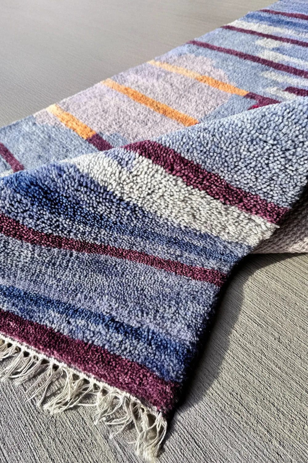 Handmade wool rug featuring deep blue and burgundy accents