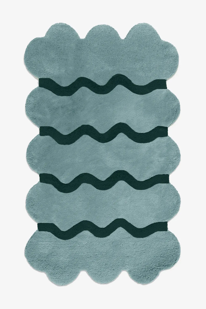 Contemporary blue scalloped edge wool rug with hand-carved wavy lines, shown in 5x7 size