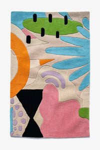 Tropical area rug with vibrant abstract shapes in teal, coral, black, and sage on cream background