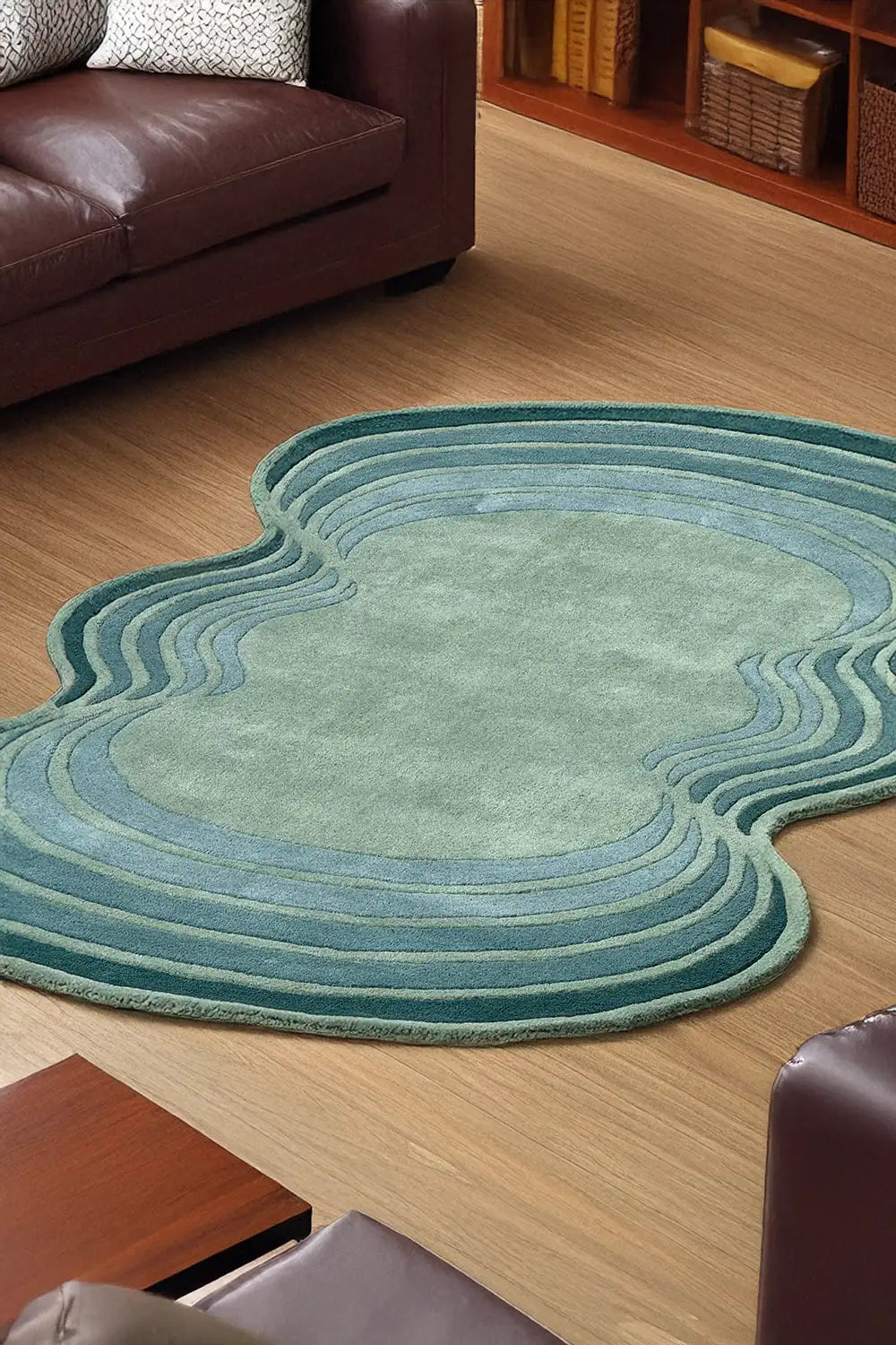 Blue and green wavy abstract rug in living room – modern irregular shaped wool rug styled with leather furniture on wood flooring