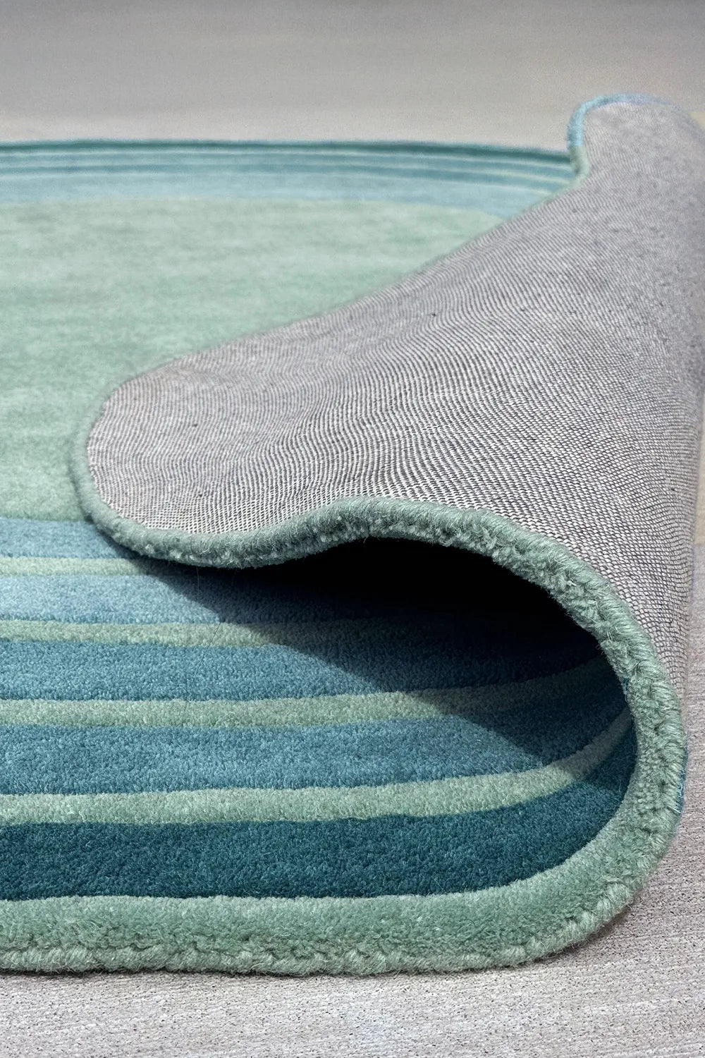 Tufted modern irregular rug with curved green stripes – high-quality wool rug with soft neutral backing


