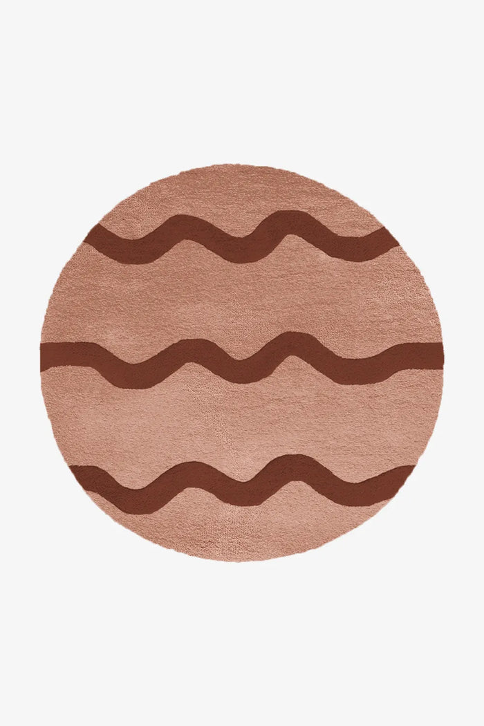 Round rust and burgundy wool rug with bold wavy stripe pattern, ideal as a mid-century living room or entryway rug