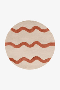 6 foot round cream and terracotta tufted wool rug with playful wavy stripe design, ideal for modern boho rooms