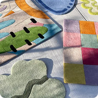 Colorful modern wool rugs in playful organic and geometric designs, shown in 5x8 and 6x9 sizes on outdoor patio