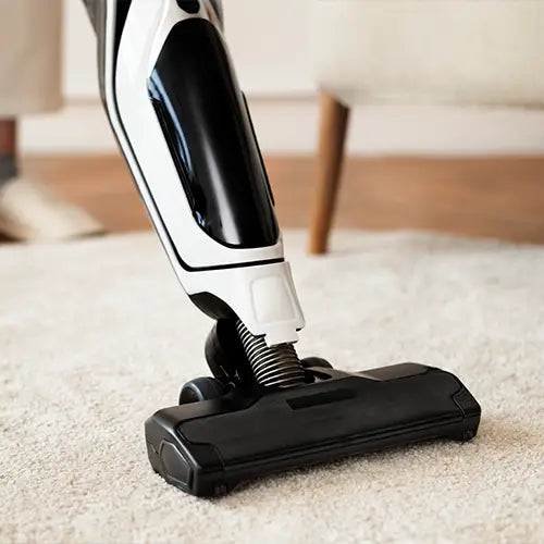 A modern vacuum cleaner being used on a high-pile beige rug, demonstrating easy maintenance and care.
