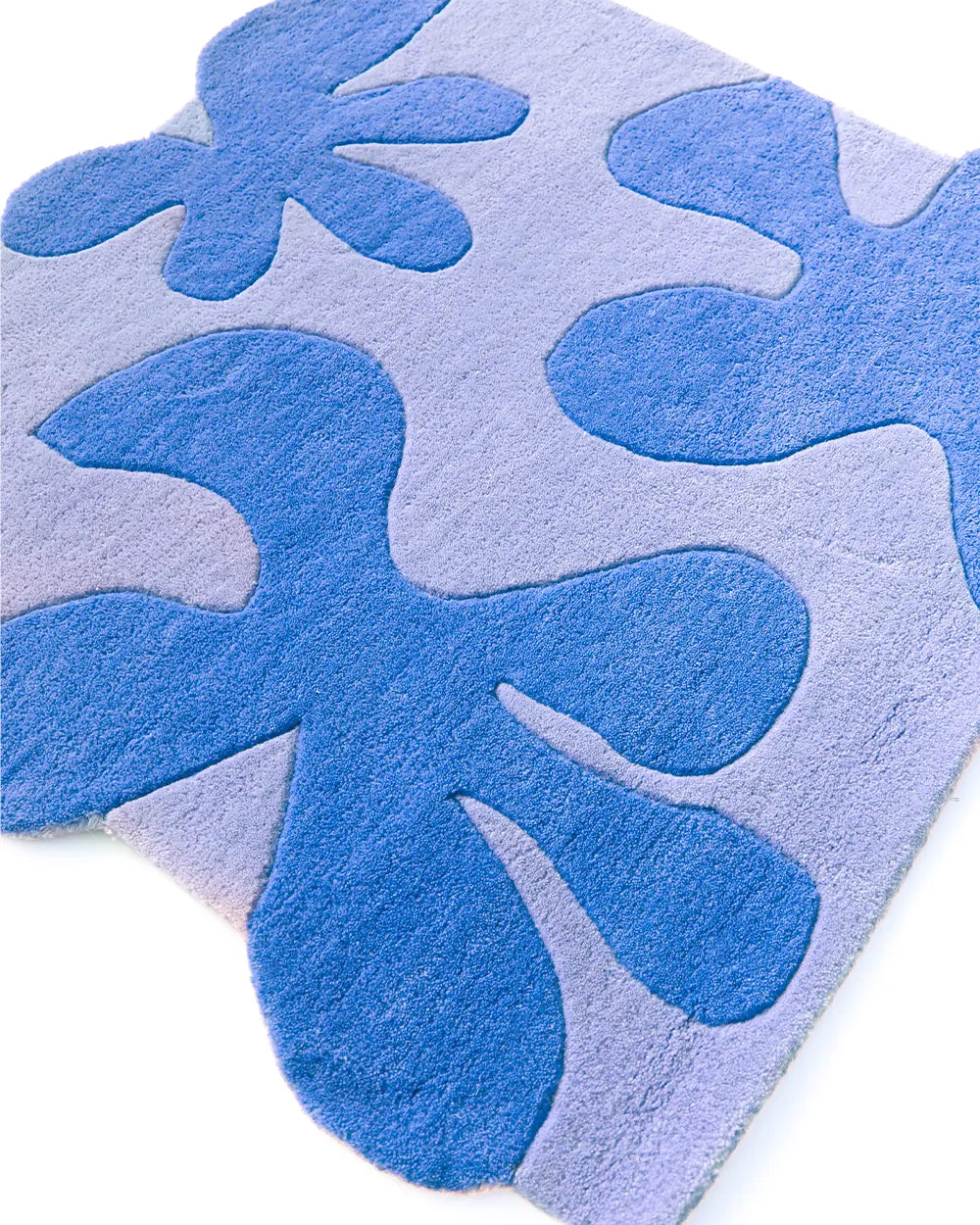 Blue Blossom Square Tufted Rug with abstract flower design in shades of darker blue on a light blue square base.