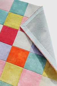 Close-up of colorful modern checkered grid rug backing with vibrant pastel squares, available in 5x5 and 6x6 sizes