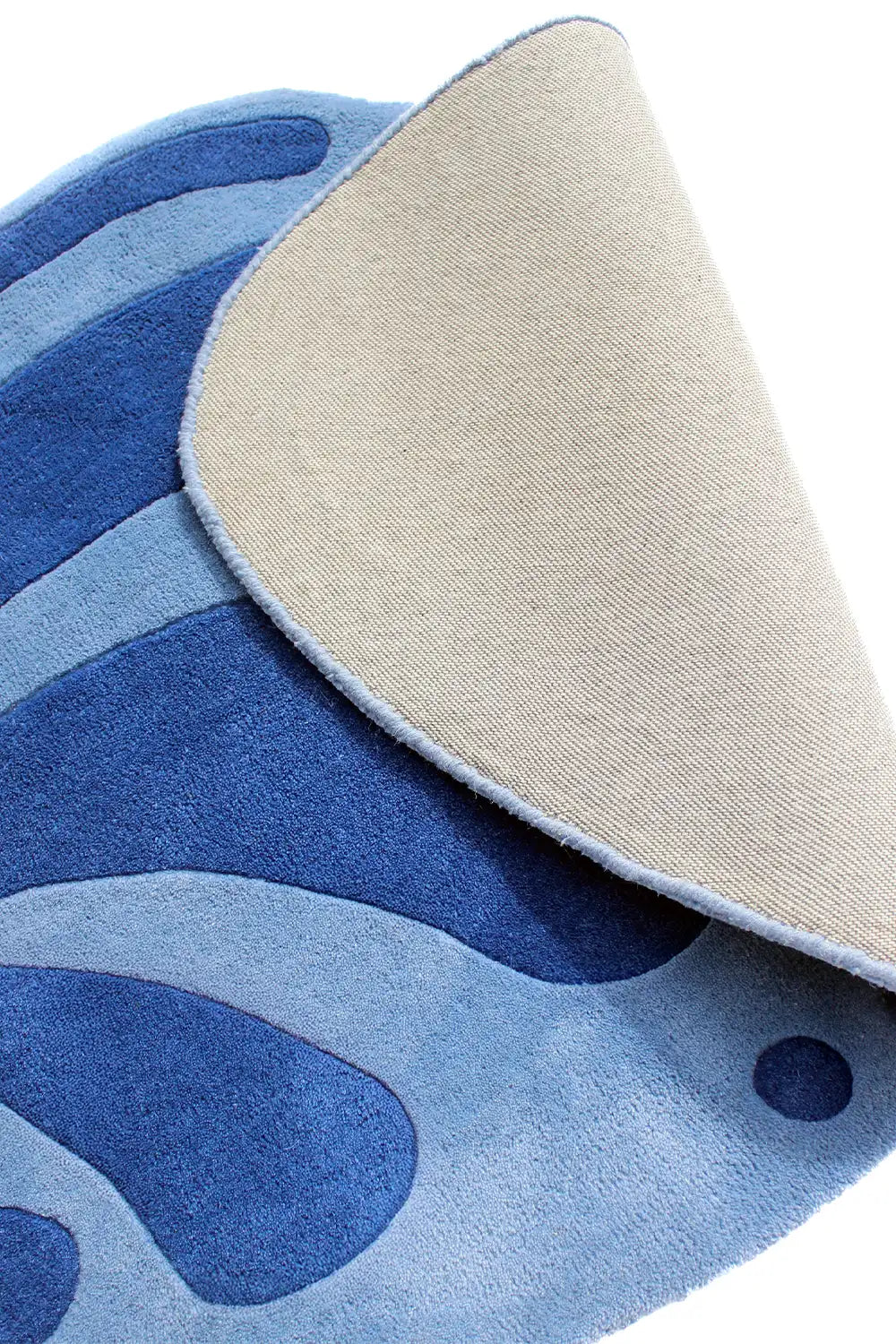 Close-up of the underside of an abstract blue floral rug with curved shape