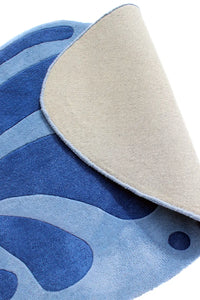 Close-up of the underside of an abstract blue floral rug with curved shape