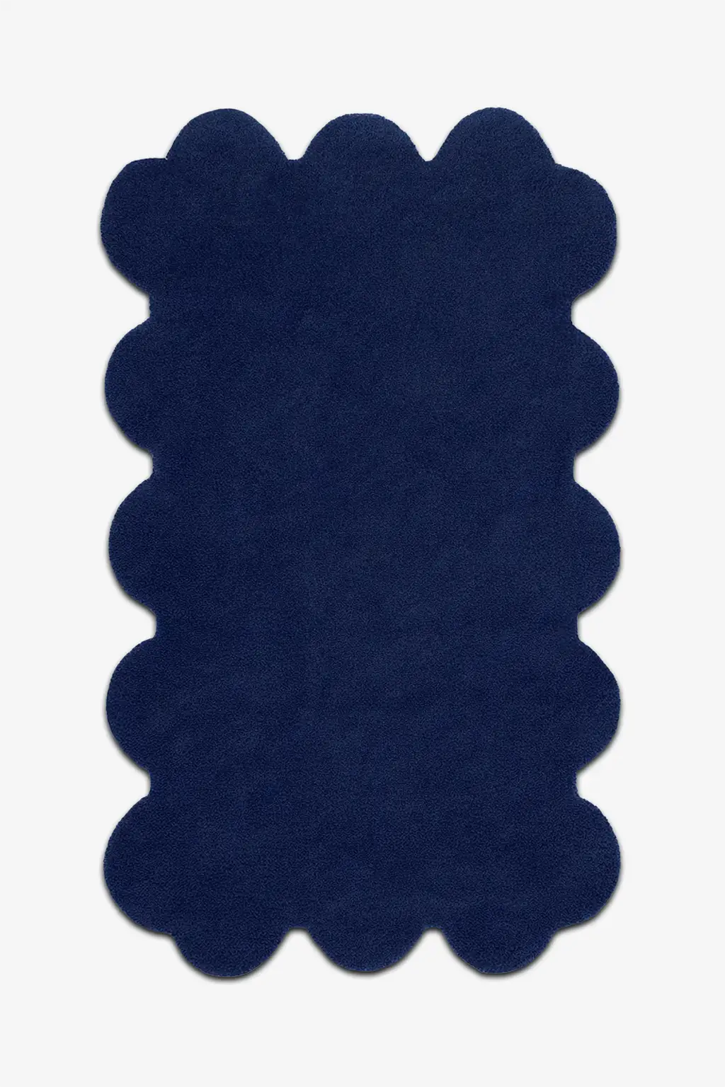 Modern navy blue scalloped rug with soft wool pile and bold sculpted edges, ideal for moody interiors

