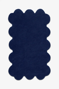 Modern navy blue scalloped rug with soft wool pile and bold sculpted edges, ideal for moody interiors

