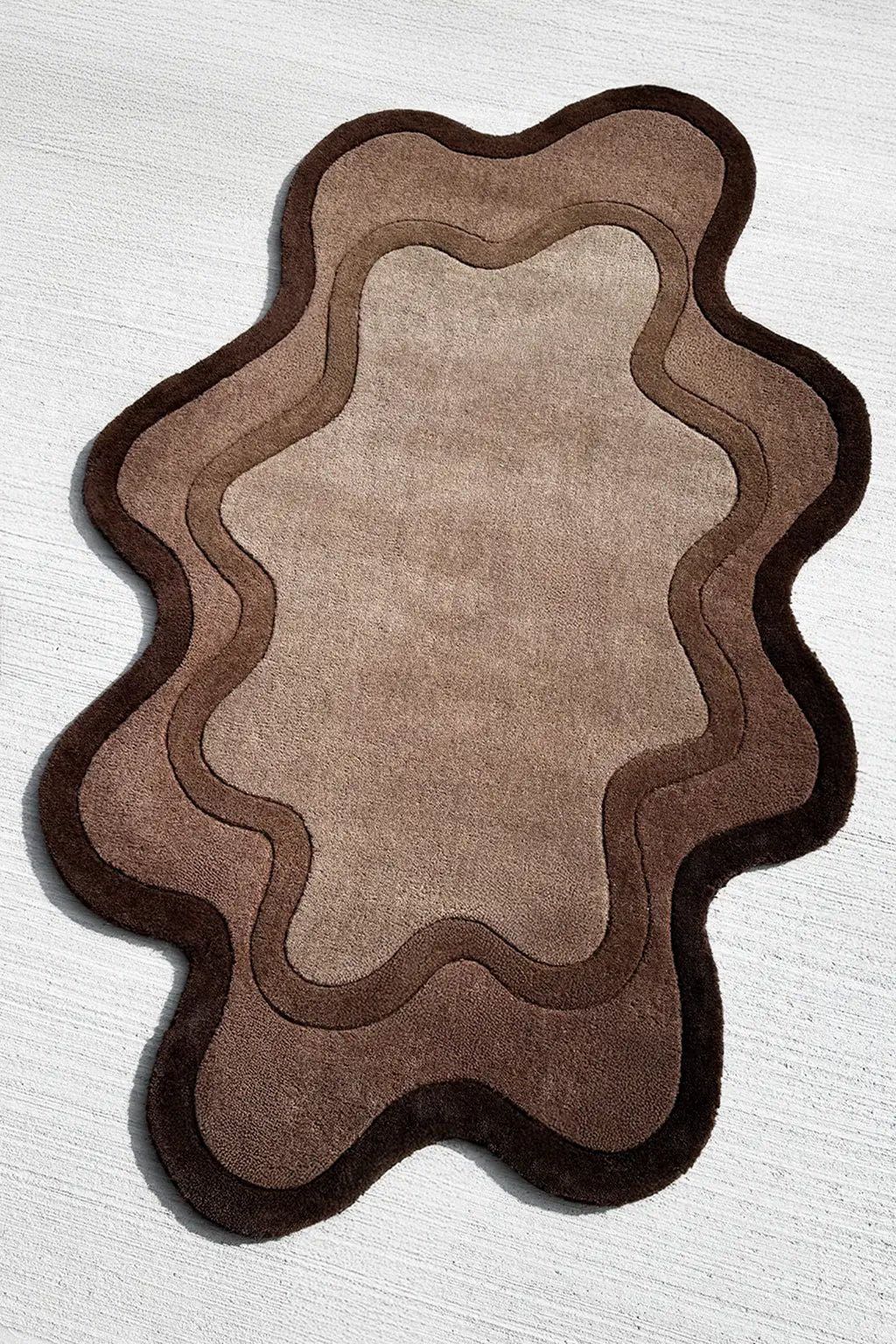 Tufted modern wool rug with abstract ripple shape in dark and light brown tones for Japandi or minimalist interiors

