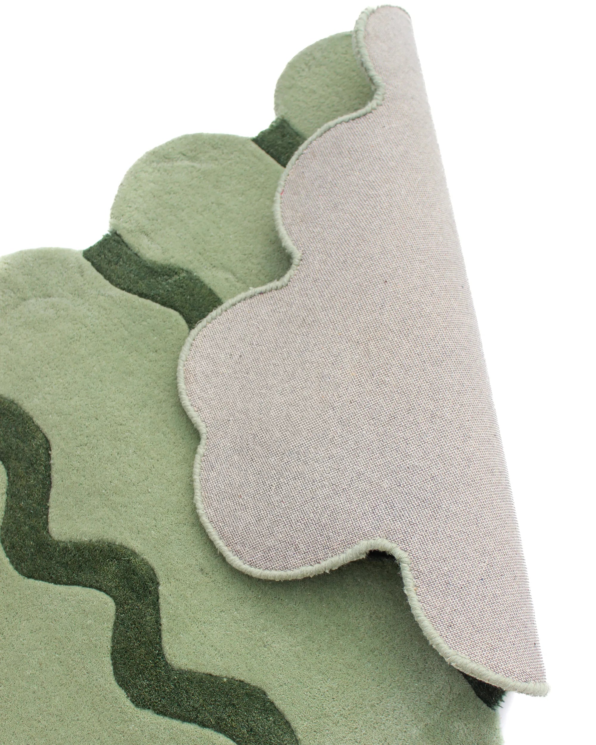 Close-up view showing the unique sculpted edges and thin wiggly stripes of the Sculpted Edge Hand Tufted Wool Rug