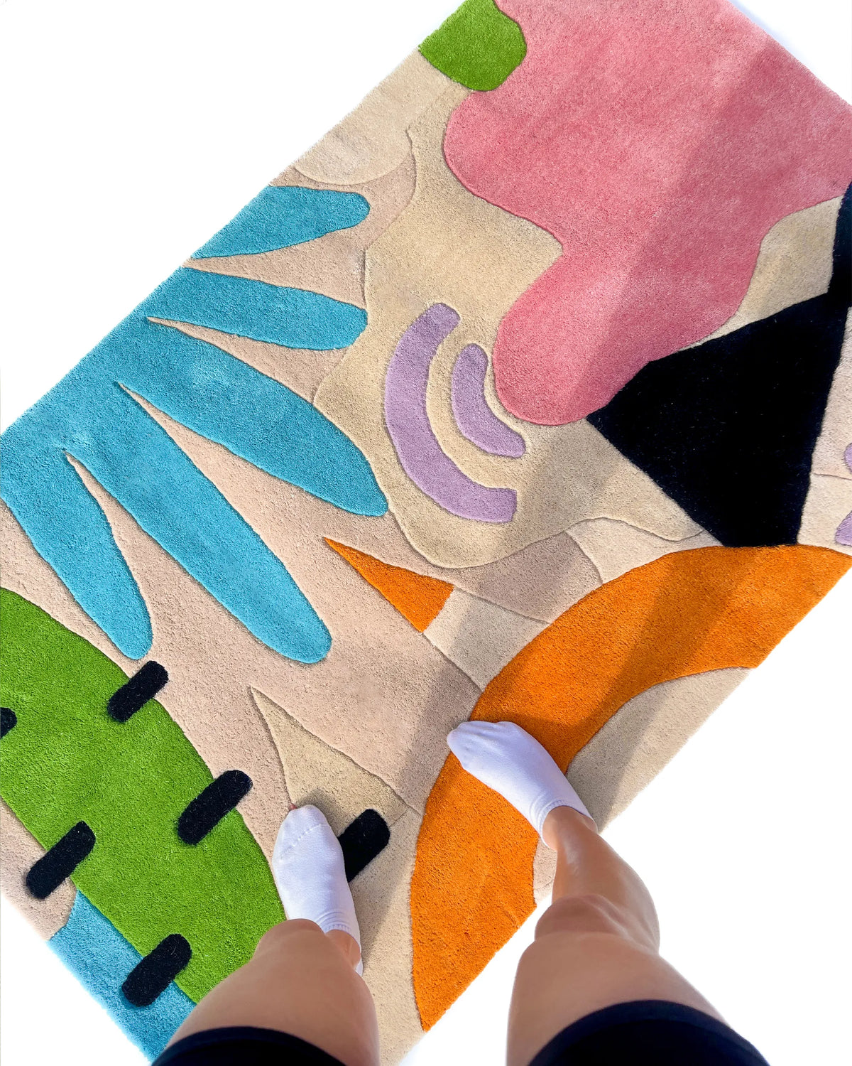 Modern funky rug in bold tropical colors placed underfoot in a bright sunlit space

