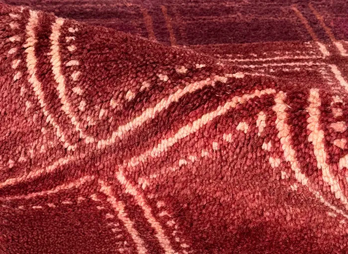 Close-up of a textured red rug with intricate patterns