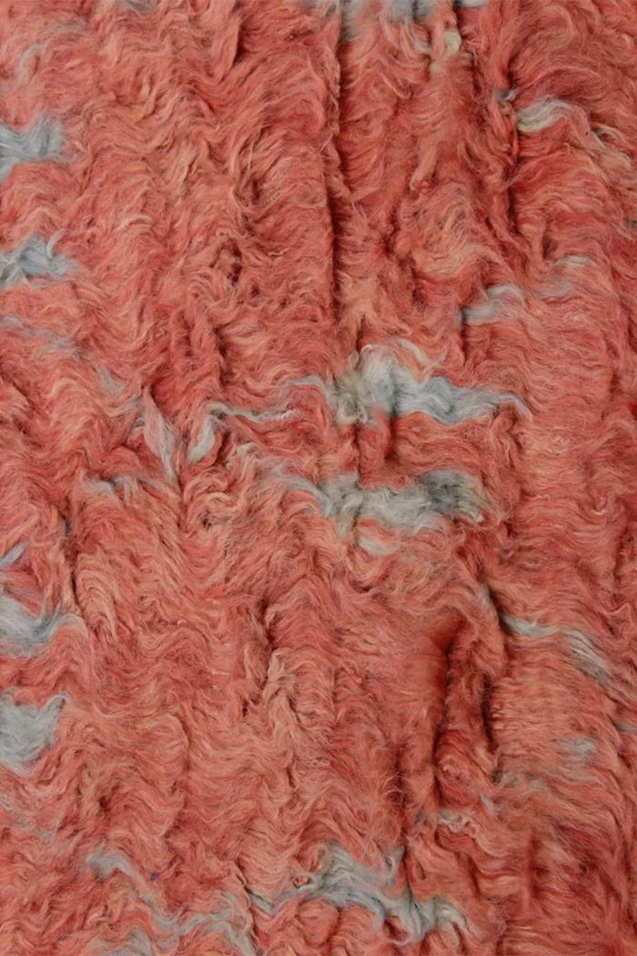 Macro detail of hand-knotted terracotta shag rug, showcasing natural movement and thick wool pile for luxury modern rug designs