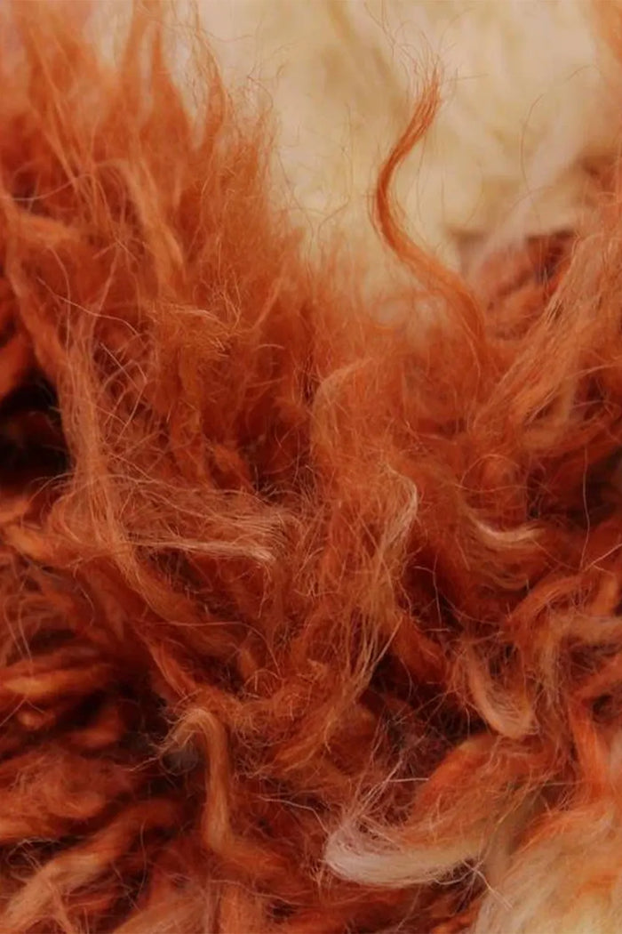 Macro of ultra-thick, soft wool shag in rich burnt orange tones, perfect for high pile rug lovers and statement cozy spaces