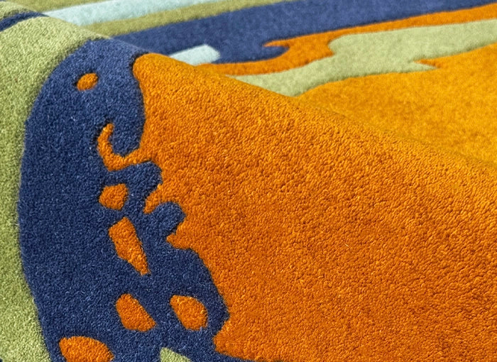 Close-up of a colorful rug with orange, blue, and green patterns.