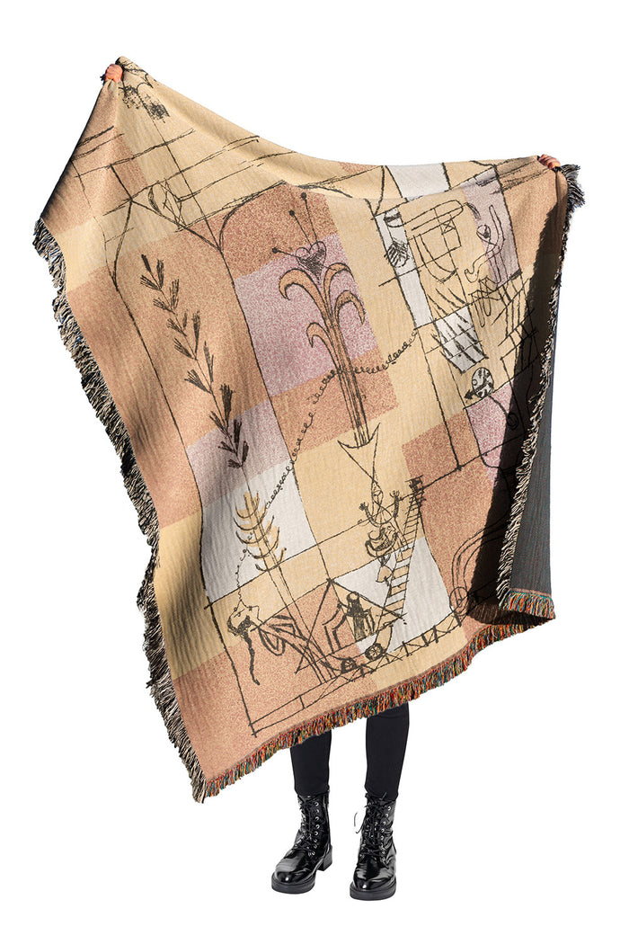 Golden yellow and burnt orange tapestry throw blanket with artistic detailing and colorful fringe.
