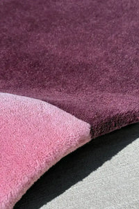 Close-up of a textured purple and pink rug surface berry