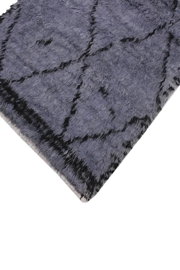 Corner detail of dark gray shag runner rug, highlighting thick wool pile and handmade tribal pattern for custom wool runner projects