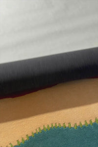 Side view of teal and orange striped rug with playful pastel color palette