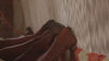 video of a group of artisans hand-knotting a rug, shown close on their hands as they use traditional tools