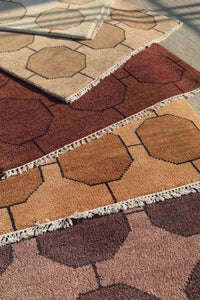 video of brown geometric rugs stacked on top of one another