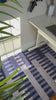 video of modern blue striped rug hand knotted from wool in a minimalist office