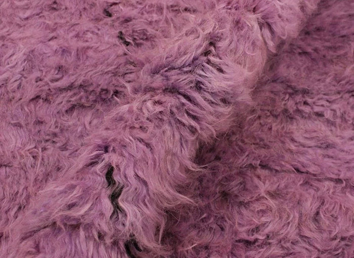 Close-up of a textured purple rug with a soft, plush appearance.