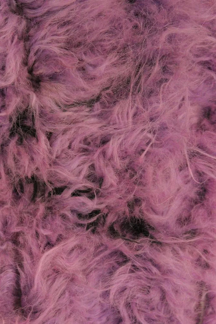 Close-up of thick purple wool shag pile with tufted black diamond details, ideal for modern boho rugs and plush bedroom floor rugs