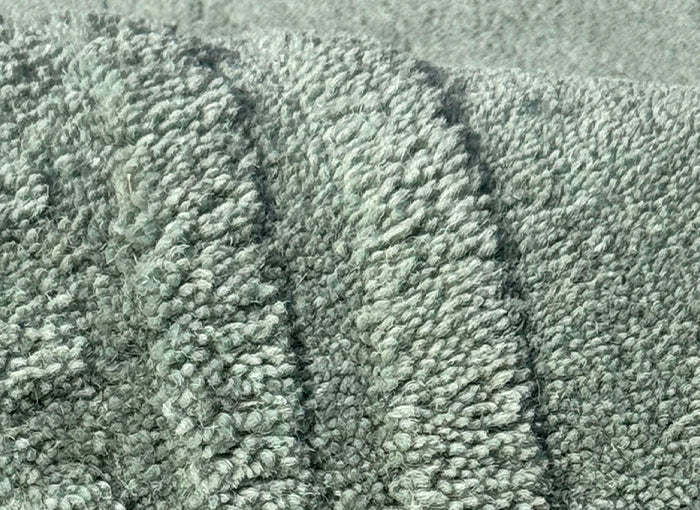 Close-up of sage green tufted wool rug