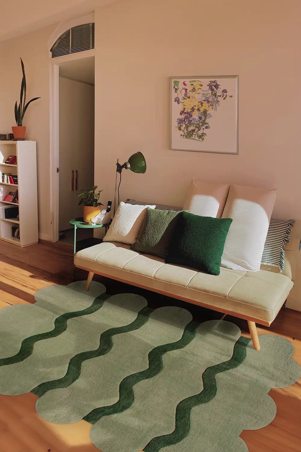 Modern living room styled with a green scalloped edge wool rug and neutral furniture.
