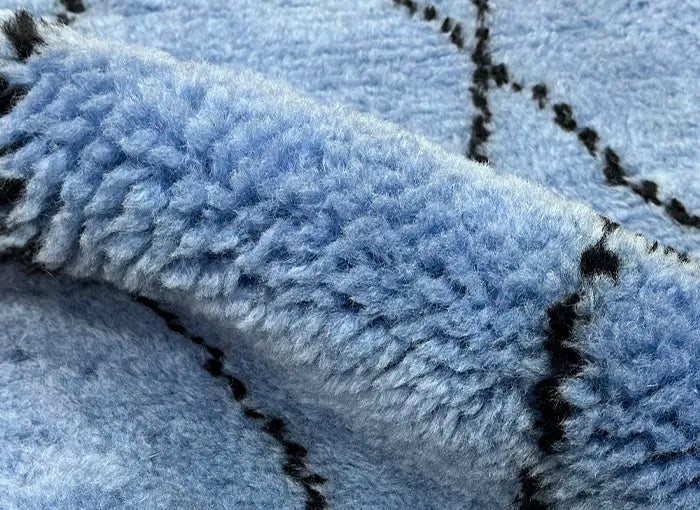Close-up of textured blue shaggy rug with a pattern